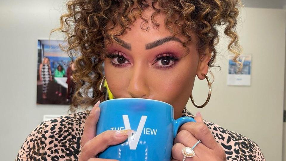 Scary Spice wearing her engagement ring while sipping from a mug