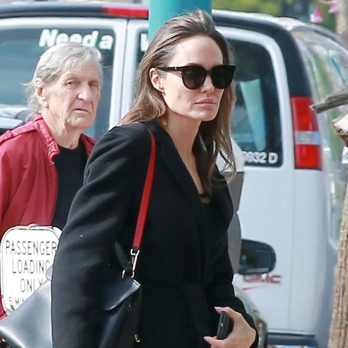 Actress Angelina Jolie walks with a Louis Vuitton bag in the