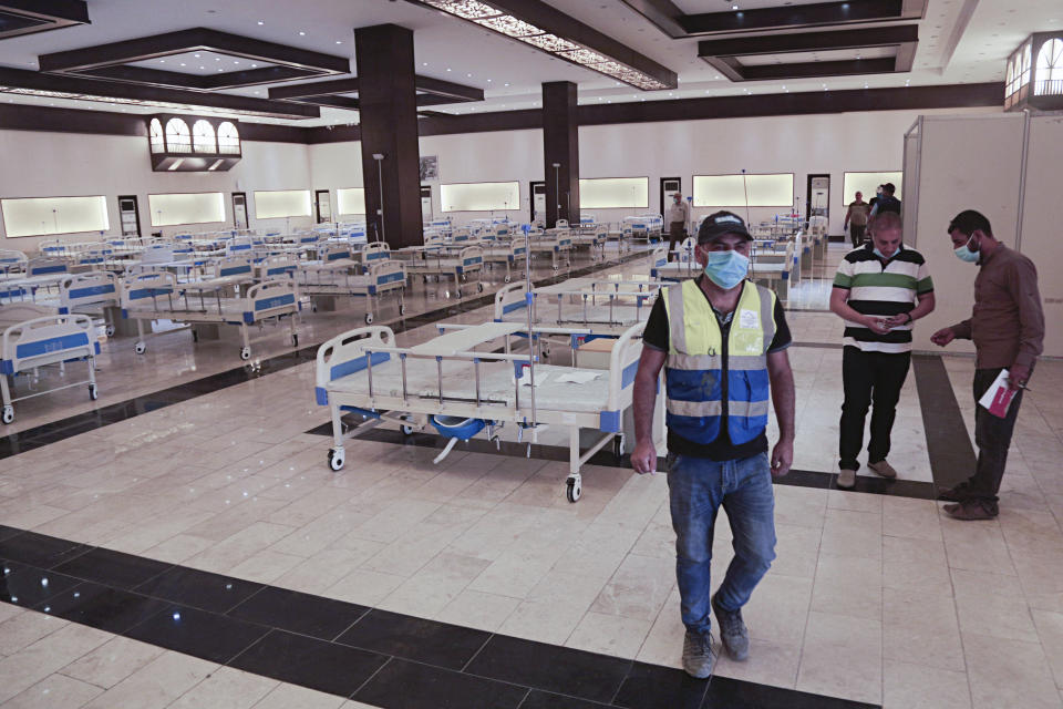 In this Saturday, June 20, 2020 photo, workers set up a field hospital to treat patients with COVID-19 in Baghdad, Iraq. New field hospitals have been erected to treat virus patients as hospitals reach capacity, but health workers fear the worst is still to come. (AP Photo/Hadi Mizban)