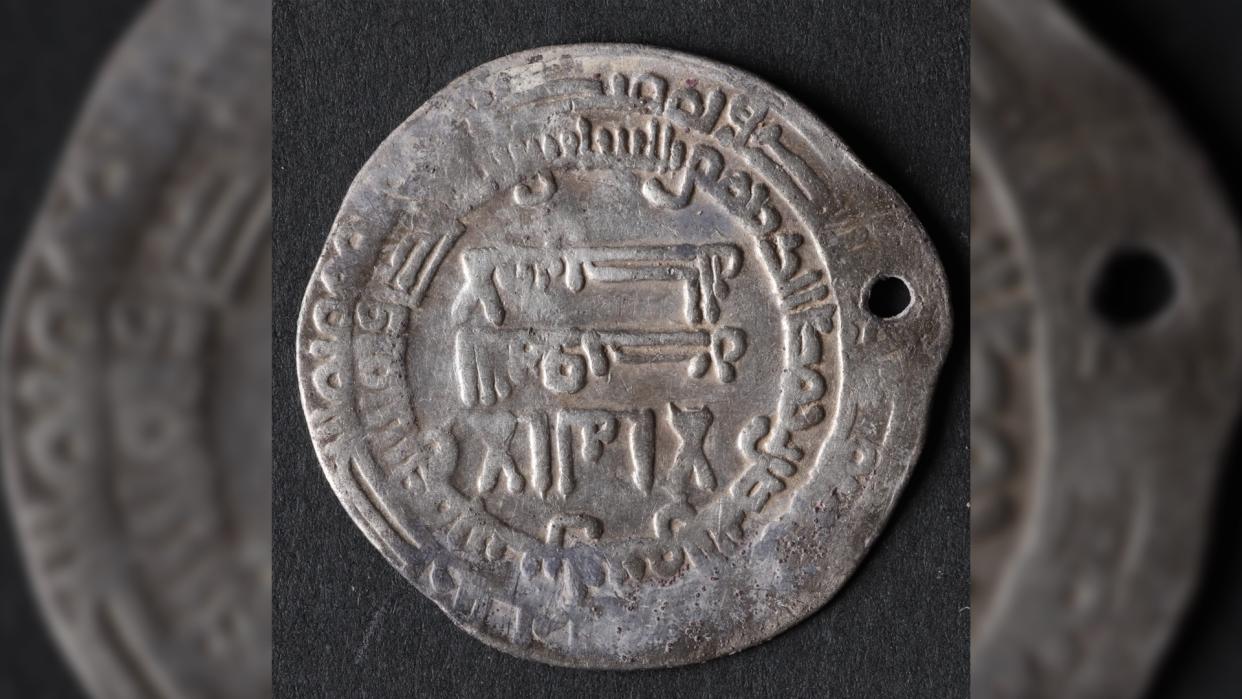  A silver coin with Arabic writing on it. 