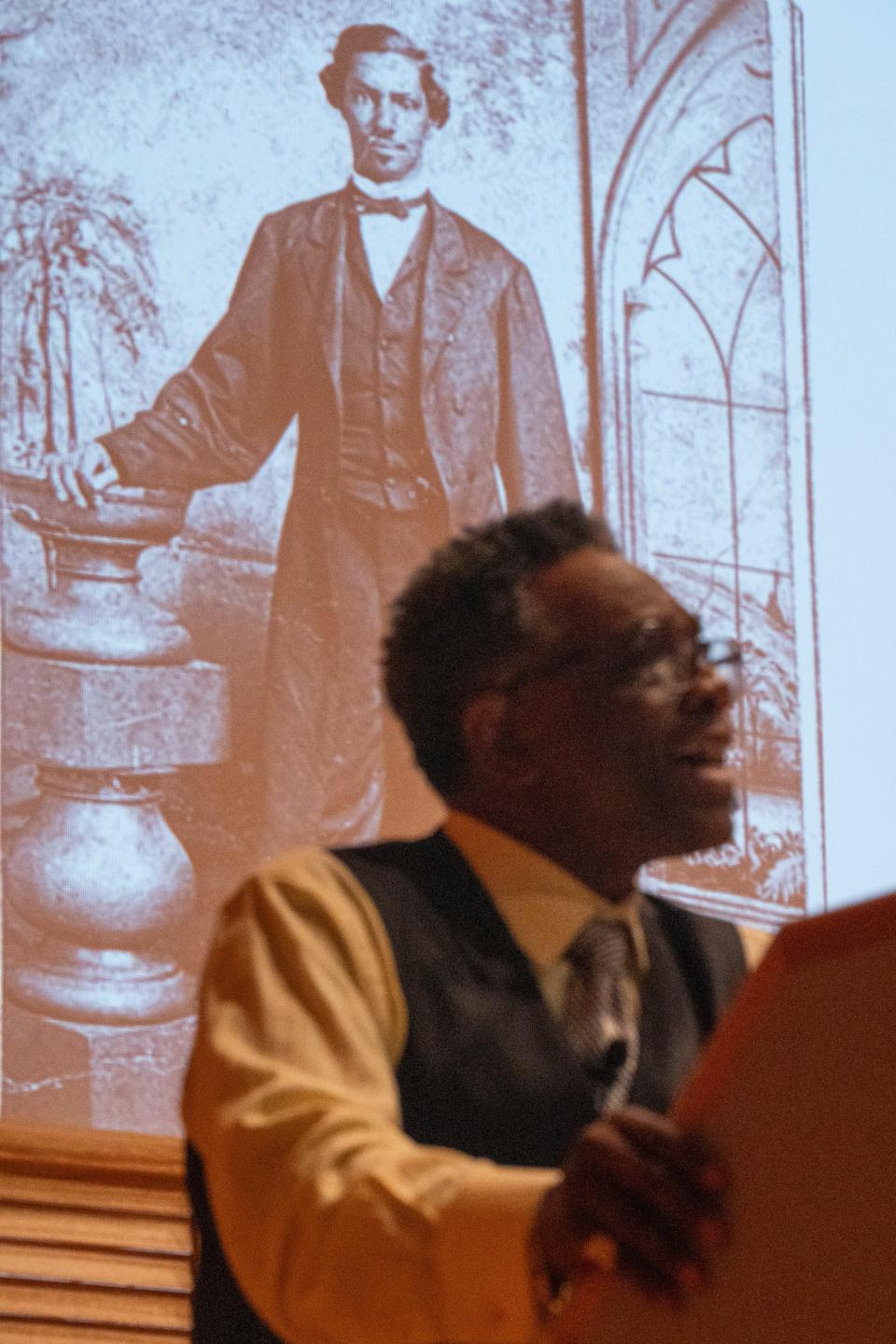 Timothy Lake, associate professor of English and Black studies, gives a keynote address about the life of John R. Blackburn, the college’s first black student, pictured on the screen behind Lake, in Salter Hall at the Fine Arts Center Monday, Feb. 5, 2024, at Wabash College in Crawfordsville, Indiana.