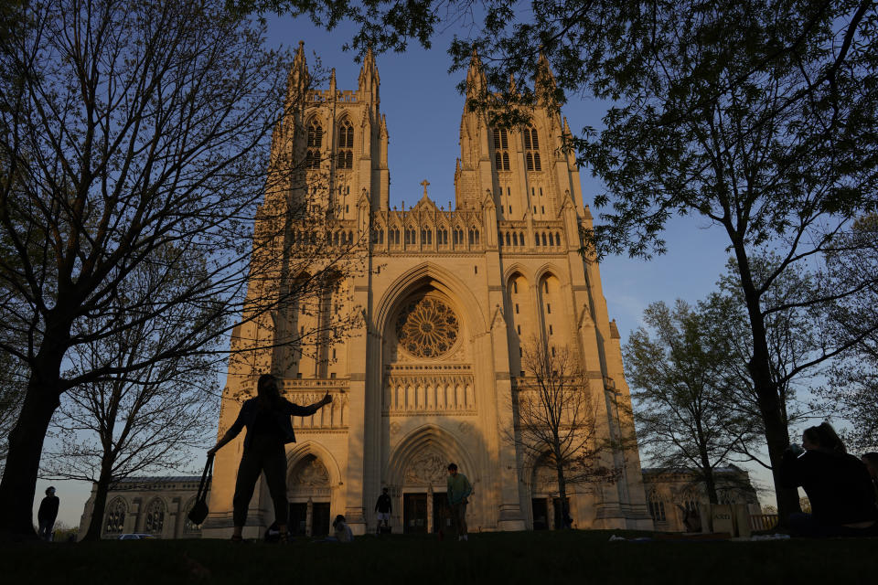 The Washington National Cathedral is seen at sunset on Tuesday, April 13, 2021. The massive Episcopal house of worship that prides itself on being an unfinished work-in-progress whose stones and stained glass tell the story of the 20th and 21st centuries, is unveiling its newest addition: a carving of iconic author, human rights campaigner and Holocaust survivor Elie Wiesel. (AP Photo/Carolyn Kaster)