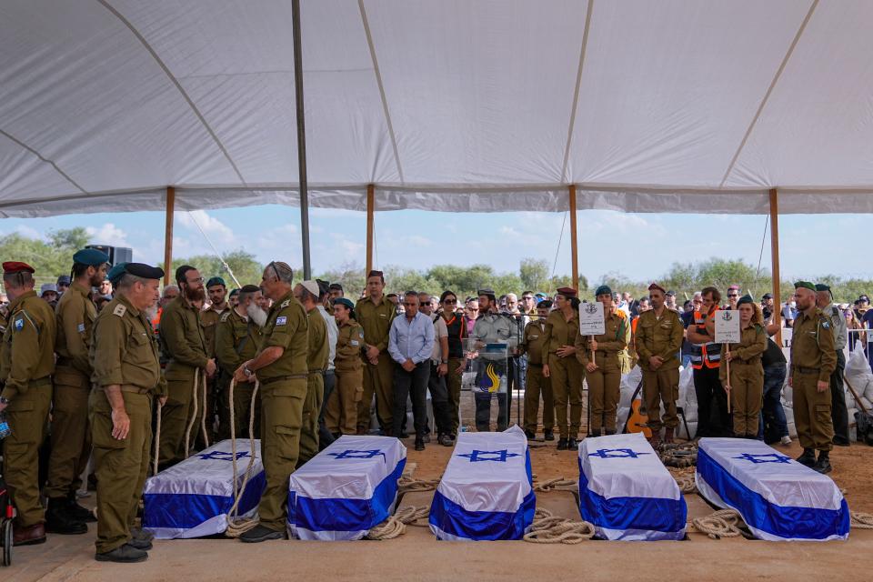 Mourners gather around the five coffins of the Kotz family during their funeral in Gan Yavne, Israel, Tuesday, Oct. 17, 2023. The family was killed by Hamas militants on October 7 at their house in Kibbutz Kfar Azza near the border with the Gaza Strip, More than 1,400 people were killed and some 200 captured in an unprecedented, multi-front attack by the militant group that rules Gaza.