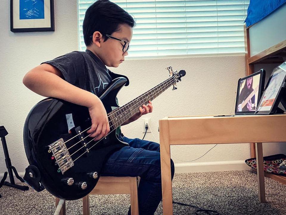 A student participates in a remote lesson through School of Rock.