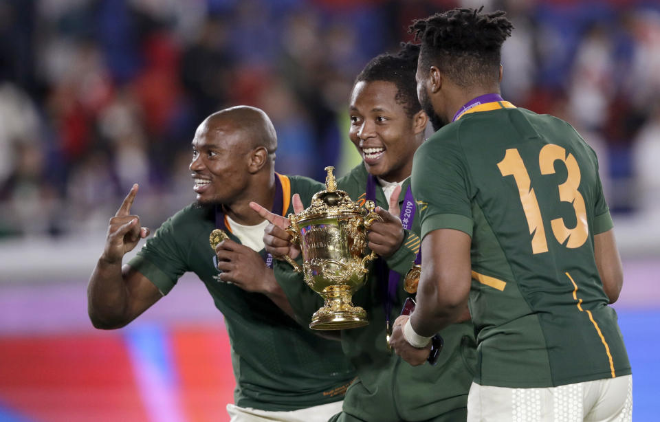 South Africa's Makazole Mapimpi, left, and Lukhanyo Am, right, celebrate with the Webb Ellis Cup after their win over England in the Rugby World Cup final at International Yokohama Stadium in Yokohama, Japan, Saturday, Nov. 2, 2019. (AP Photo/Aaron Favila)