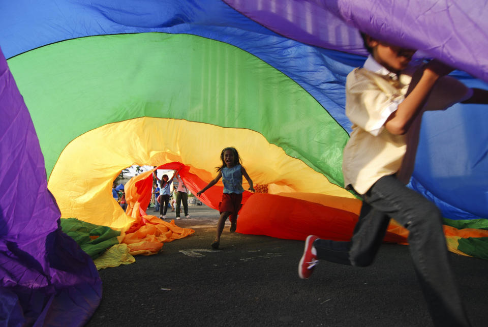 A boy plays under a rainbow flag during the Manila Gay Pride march on December 8, 2012 in Makati, Philippines. &nbsp;(Photo by Dondi Tawatao/Getty Images)