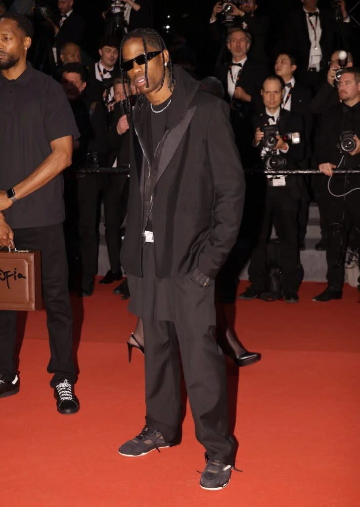 Travis Scott on the red carpet in a black suitt