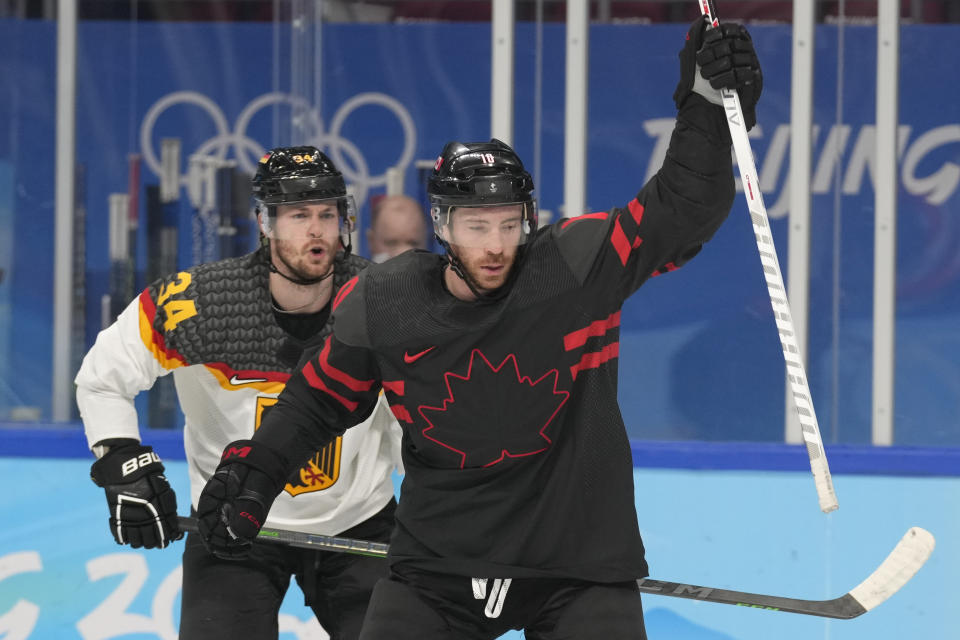 Canada's Ben Street (10) celebrates after scoring a goal against Germany during a preliminary round men's hockey game at the 2022 Winter Olympics, Thursday, Feb. 10, 2022, in Beijing. Behind Street is Germany's Tom Kuhnhackl (34). (AP Photo/Petr David Josek)