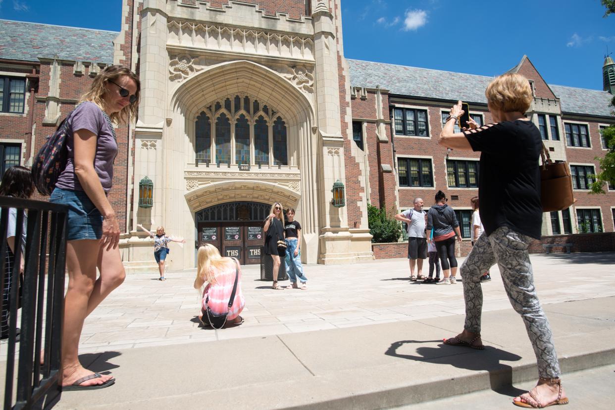 Ukrainian refugee teenagers and their families take photos outside of Topeka High on Tuesday as they prepare to attend a U.S. high school for the first time.