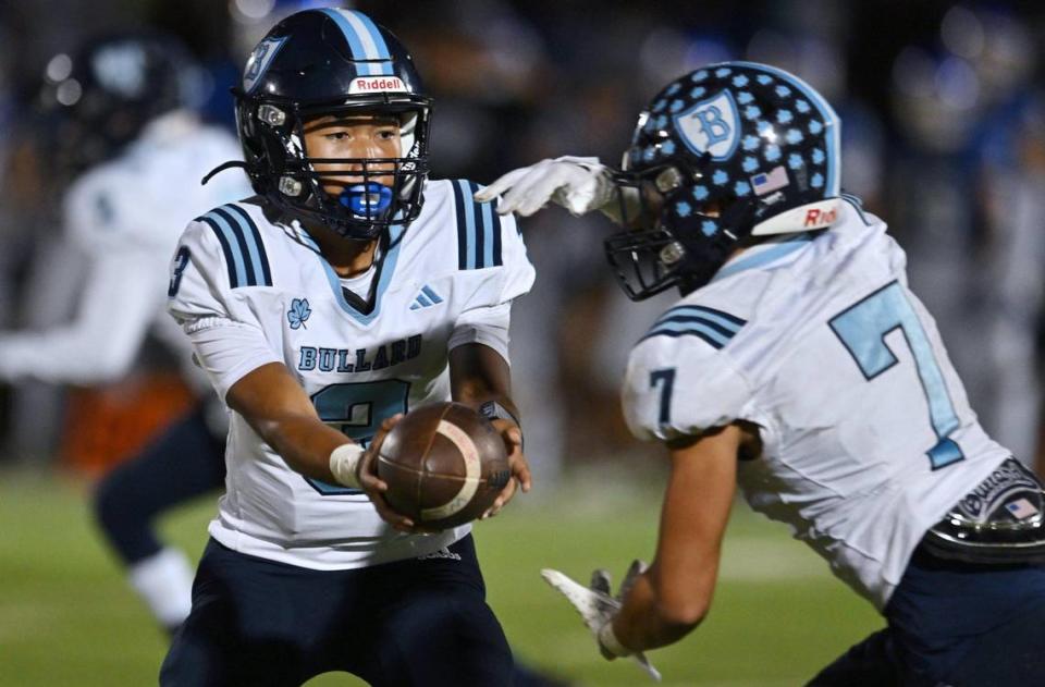 Bullard quarterback Jerren Mao, left, hands off to Dominick Gonzalez, right, in a CMAC game against Madera Friday, Sept. 29, 2023 in Madera. Madera led 6-0 at halftime, but Bullard rallied for the 7-6 win.