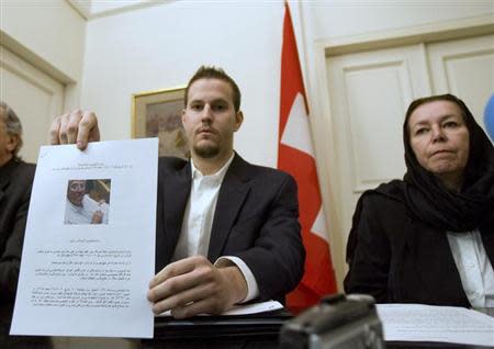 Christine Levinson (R), wife of former FBI agent Robert Levinson, watches as her son Daniel Levinson displays a web print of his father's picture to journalists while attending a news conference at Switzerland's embassy in Tehran December 22, 2007. REUTERS/Morteza Nikoubazl