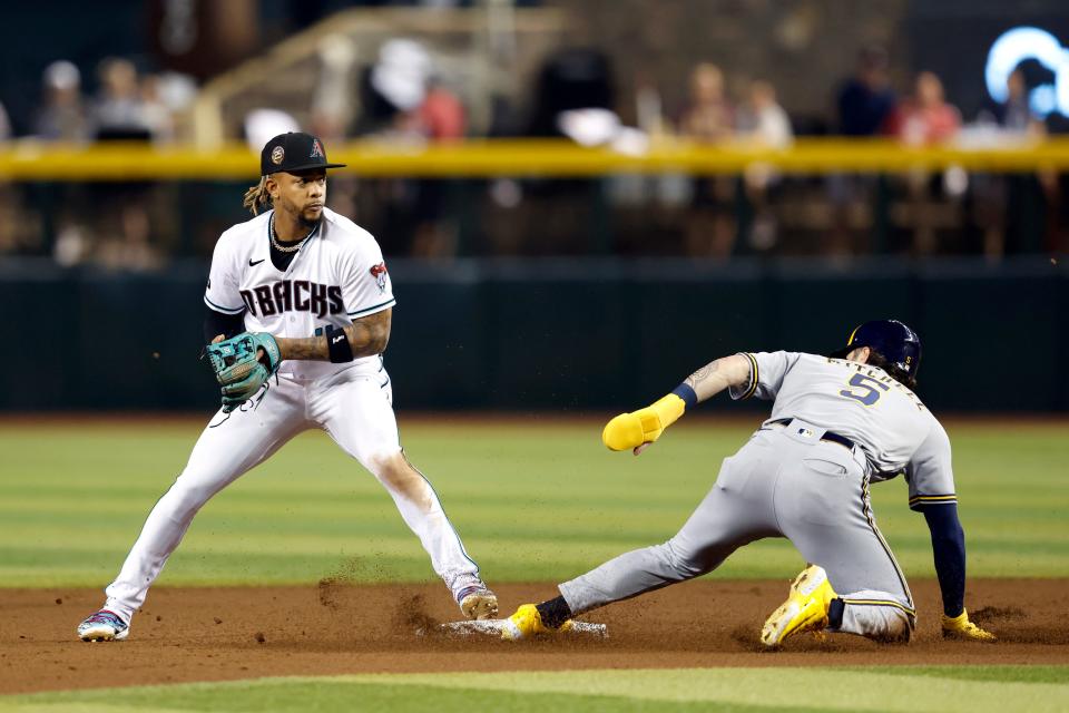Ketel Marte (4) of the Arizona Diamondbacks turns a double play over Garrett Mitchell (5) of the Milwaukee Brewers during the fifth inning at Chase Field on April 10, 2023, in Phoenix.