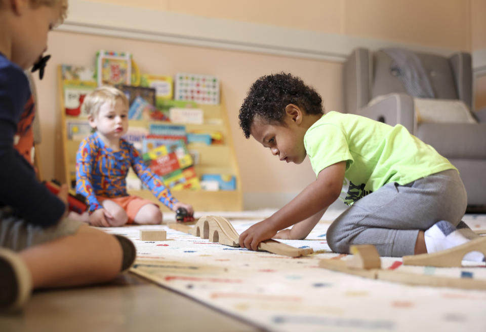 Elijah Rollings, 2, plays with a train set at Bumble Art Studio day care center in Astoria, Ore., Friday, Sept. 2, 2022. From Oregon to New York, demand for child care far exceeds supply. Families are growing increasingly desperate as providers deal with staffing shortages exacerbated by the coronavirus pandemic as well as historically low pay worsened by inflation. (AP Photo/Craig Mitchelldyer)