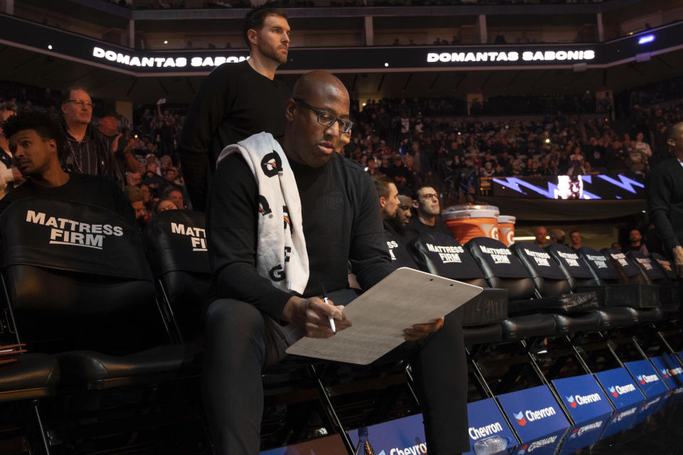 Sacramento Kings coach Mike Brown looks over his notes before the team's NBA basketball game against the Houston Rockets in Sacramento, Calif., Wednesday, Jan. 11, 2023. (AP Photo/José Luis Villegas)