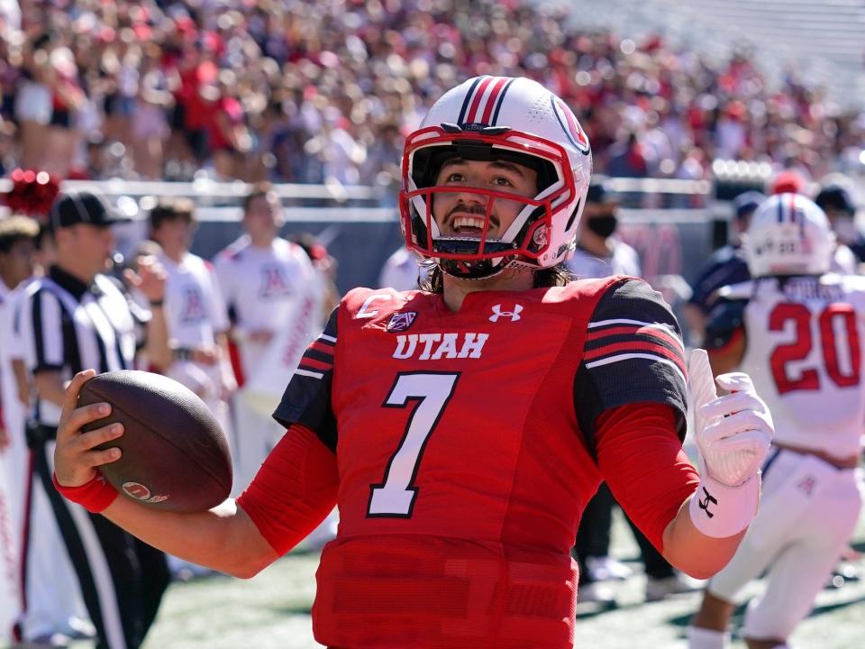 Cameron Rising holds the football and smiles during a game in 2021.