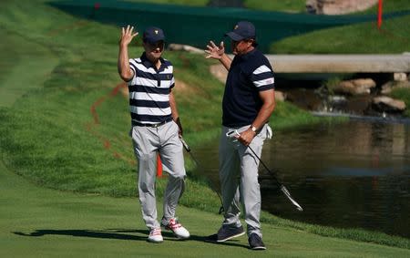 Sep 28, 2017; Jersey City, NJ, USA; Golfers Kevin Kisner (left) and Phil Mickelson celebrate a made putt by Kisner on the first hole during the first round foursomes match of The President's Cup golf tournament at Liberty National Golf Course. Mandatory Credit: Kyle Terada-USA TODAY Sports