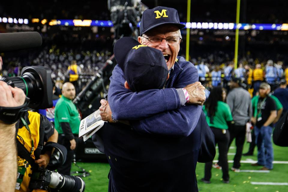 Michigan coach Jim Harbaugh hugs his dad, Jack, after the Wolverines won the national championship on Monday.