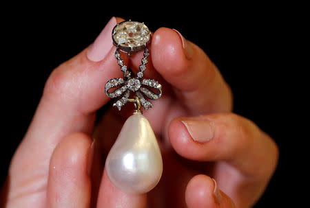 FILE PHOTO: A natural pearl and diamond pendant once owned by Marie Antoinette is held by a model during a press preview ahead of the upcoming auction "Royal jewels from the Bourbon Parma Family" at Sotheby's in Geneva, Switzerland November 7, 2018. REUTERS/Denis Balibouse/File Photo