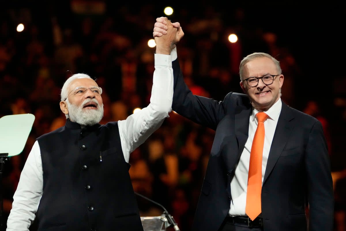 Indian Prime Minister Narendra Modi, left, holds hands with his Australian counterpart Anthony Albanese (AP)