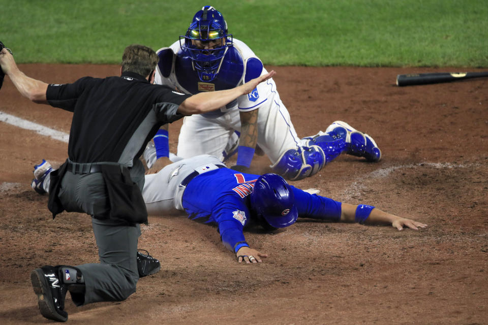 Chicago Cubs catcher Victor Caratini (7) is called safe by home plate umpire Alex Tosi, during the ninth inning of a baseball game at Kauffman Stadium in Kansas City, Mo., Wednesday, Aug. 5, 2020. Kansas City Royals catcher Salvador Perez, top, was late with the tag. The Cubs defeated the Royals 6-1. (AP Photo/Orlin Wagner)