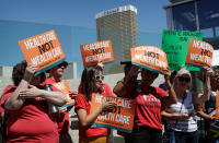<p>People protest with the Trump International hotel in the background, Tuesday, June 27, 2017, in Las Vegas. Union officials in Nevada, community members and others gathered Tuesday at a pedestrian bridge over the Las Vegas Strip to urge Republican U.S. Sen. Dean Heller to continue to oppose the current GOP health care bill. (Photo: John Locher/AP) </p>