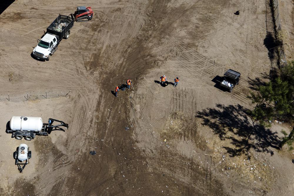 Crews clear an area where migrants, many from Haiti, were encamped along the Del Rio International Bridge, Friday, Sept. 24, 2021, in Del Rio, Texas. (AP Photo/Julio Cortez)