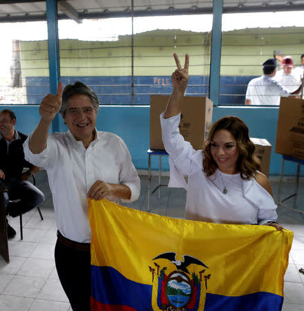 Ecuadorean presidential candidate Guillermo Lasso and his wife Maria de Lourdes Alcivar pose with an Ecuadorean flag after Lasso casted his vote during the presidential election in Guayaquil, Ecuador April 2, 2017. REUTERS/Henry Romero