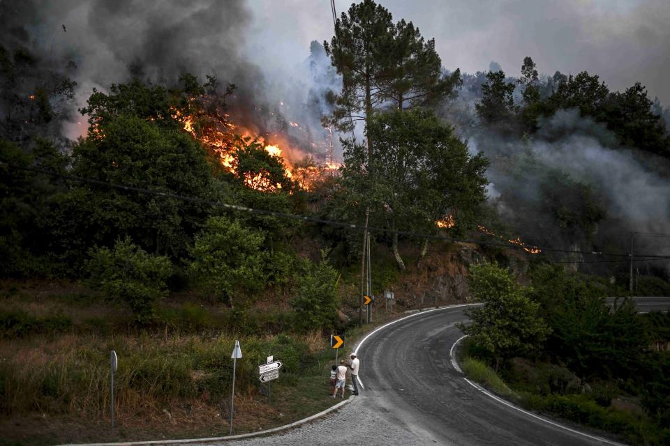 Villagers watch the progression of a wildfire at Eiriz in Baiao, north of Portugal, on July 15, 2022. (Photo by PATRICIA DE MELO MOREIRA / AFP) (Photo by PATRICIA DE MELO MOREIRA/AFP via Getty Images)