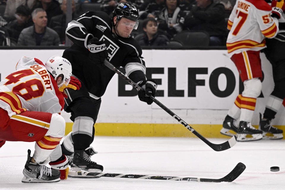 Los Angeles Kings right wing Arthur Kaliyev shoots as Calgary Flames defenseman Dennis Gilbert (48) defends during the second period of an NHL hockey game in Los Angeles, Saturday, Dec. 23, 2023. (AP Photo/Alex Gallardo)