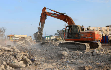 Workers clear the rubble from the scene of last Saturday explosion in KM4 street in the Hodan district in Mogadishu, Somalia October 17, 2017. REUTERS/Feisal Omar