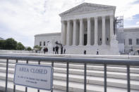 Law enforcement officers stand behind barricades outside the Supreme Court on Thursday, June 27, 2024, in Washington. (AP Photo/Mark Schiefelbein)