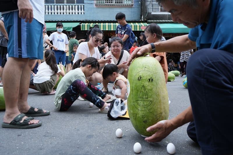 來自高雄的謝姓民眾一家人，10日到屏東縣佳冬鄉石光見廣惠宮三山國王廟前體驗立瓜，並自備蛋延續端午立蛋傳統。（中央社）