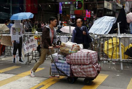 A pro-democracy protester transports supplies on a trolley from a protest site on the blocked Nathan Road, part of the Occupy Central civil disobedience movement, at Mongkok shopping district in Hong Kong November 12, 2014. REUTERS/Bobby Yip