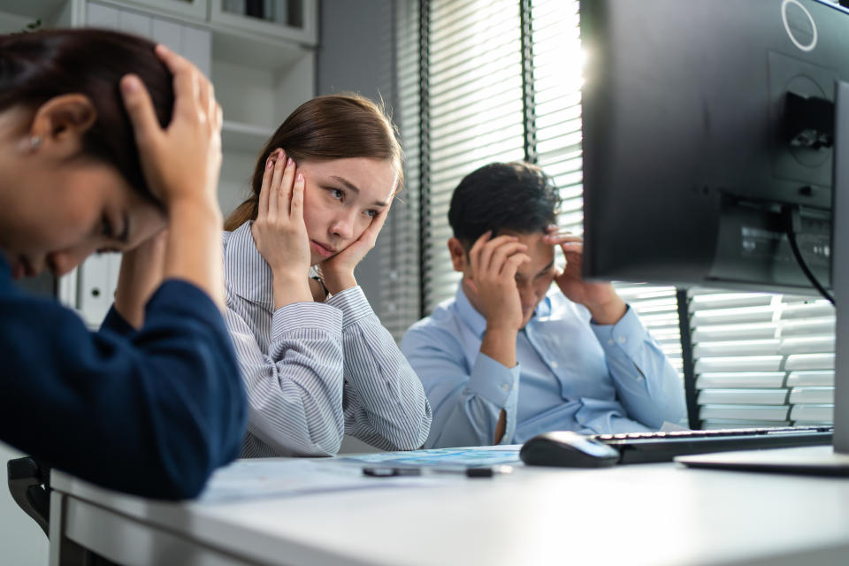 Cacasian business woman call center having headache in office place. Attractive young beautiful employee worker sit on table, wear headset and use laptop computer talk to support customer at workplace