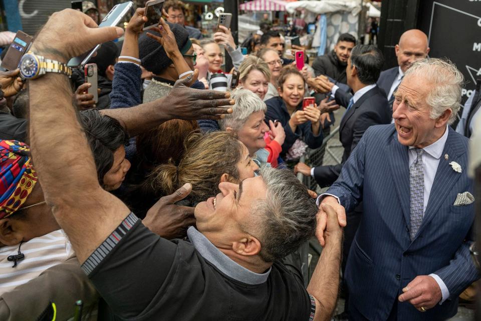 Britain's Prince Charles, Prince of Wales (R) shakes hands and poses for selfie photographs with members of the public in Walworth in south London during a visit to The Prince's Trust Kickstart supported young people at JD Sports on May 11, 2022.