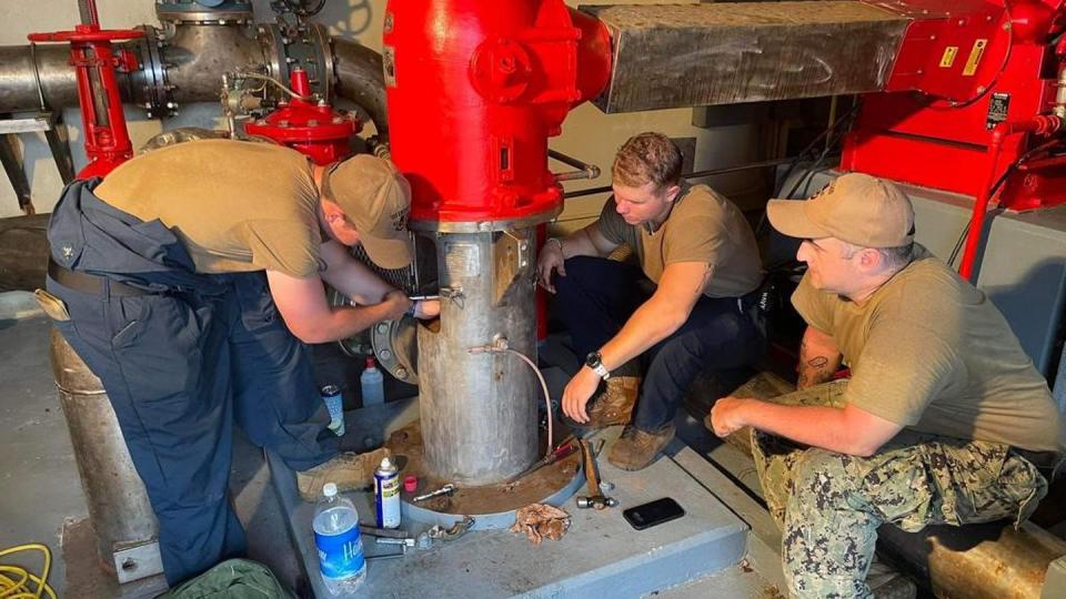Sailors assigned to the submarine tender Emory S. Land work on a fire pump diesel pipe on Naval Base Guam June 7 as part of efforts to help repair buildings after Typhoon Mawar. (Courtesy of Lt. j.g. William Churchill/Navy)