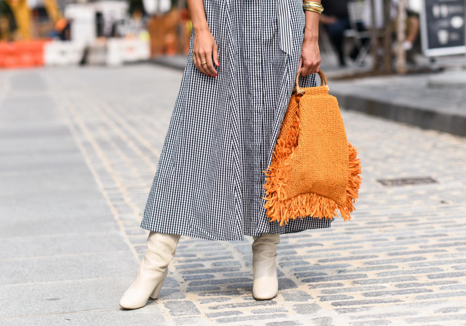 A guest is seen wearing checkered black and white dress with an orange bag and white boots outside the Alice and Olivia show during New York Fashion Week S/S21 on September 16, 2020 in New York City. (Photo by Daniel Zuchnik/Getty Images)