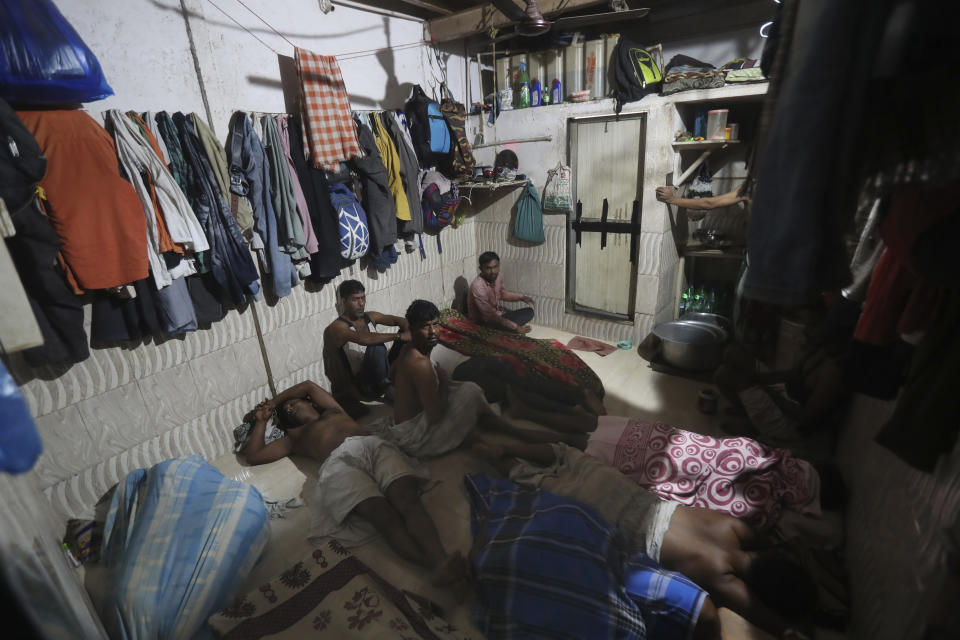 Migrant laborers from state of West Bengal, who recently returned back to Mumbai, India, sit together in their shared room as they wait for their turn for the restroom, Tuesday, Nov. 23, 2020. (AP Photo/Rafiq Maqbool)