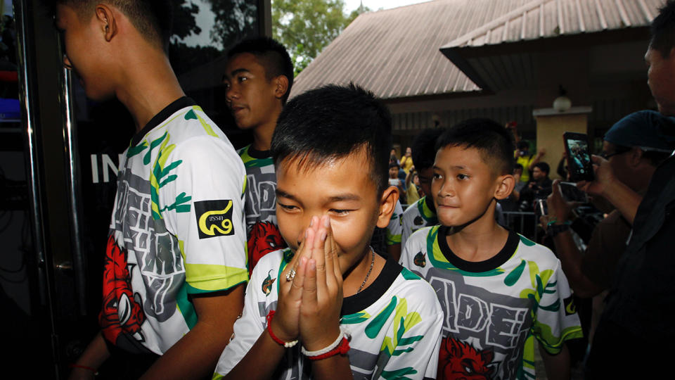 Some of the Wild Boar soccer team greet the media as they arrive for their first press conference since their rescue. Source: AAP
