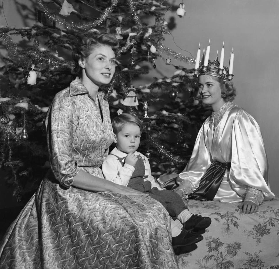 <p>Ingrid Bergman incorporates her Swedish traditions into the holidays, as she poses by her Christmas tree with her son in 1952. </p>