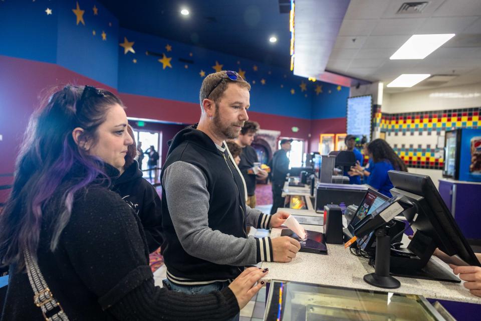 Twinsburg resident Michael McCafferty, his wife, Nicole, and daughter Quinn visit the concession stand at the newly opened Atlas Cinemas Barrington 10 in Aurora. The moviegoers are very happy the theater has opened again, as they have had long drives to see movies over the past few years.