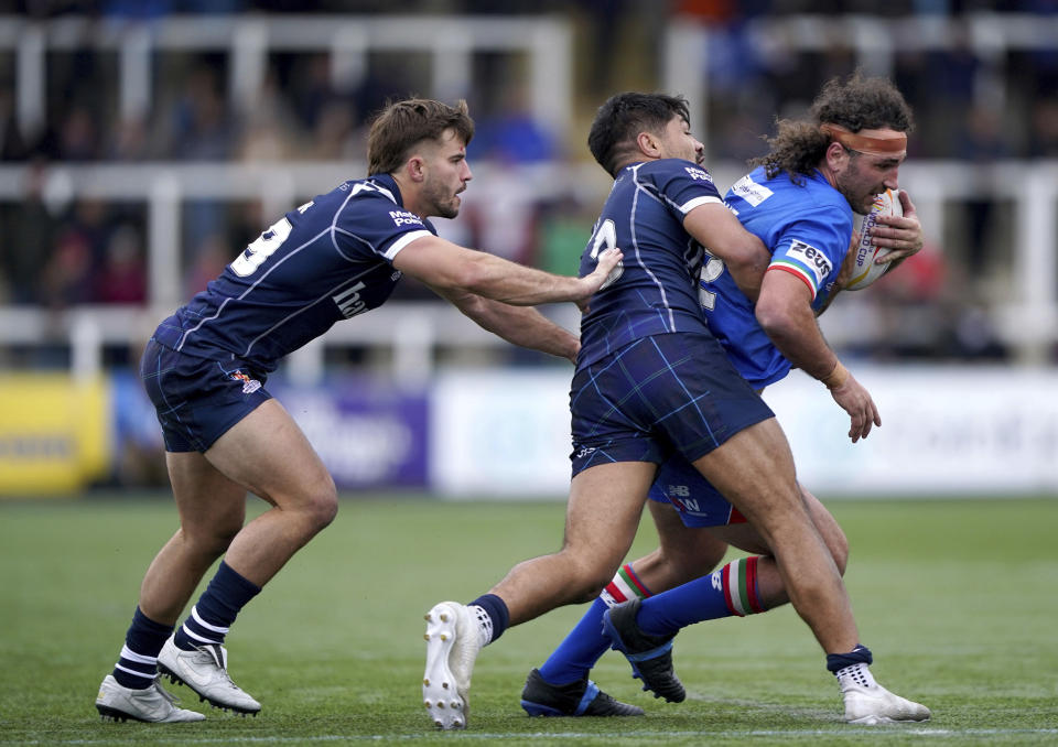 Italy's Brenden Santi is tackled by Scotland's James Bell during the Rugby League World Cup group B match between Scotland and Italy at Kingston Park, Newcastle upon Tyne, England, Sunday Oct. 16, 2022. (Owen Humphreys/PA via AP)