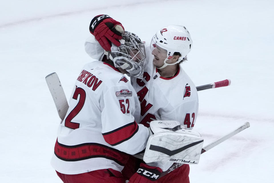 Carolina Hurricanes goaltender Pyotr Kochetkov, left, celebrates with defenseman Maxime Lajoie after their shutout of the Chicago Blackhawks in an NHL hockey game Monday, Nov. 14, 2022, in Chicago. (AP Photo/Charles Rex Arbogast)