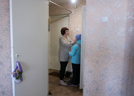 School teacher Olga Markelova, ex-wife of Russian military contractor Dmitry Markelov who was killed by a mine in Syria, gets her daughter dressed in an apartment in Nizhnekamsk, Russia February 11, 2019. REUTERS/Maria Stromova