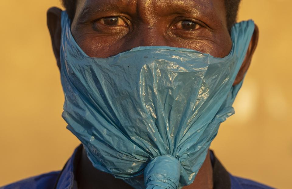 FILE — In this May 6, 2020 file photo a man wears a plastic bag for a mask on his face as a precaution against the spread of the coronavirus, in Katlehong, Johannesburg. (AP Photo/Themba Hadebe, File)