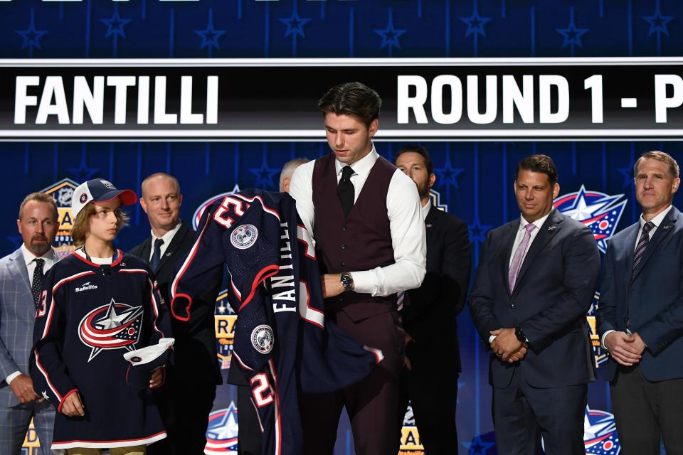 Jun 28, 2023; Nashville, Tennessee, USA; Columbus Blue jackets draft pick Adam Fantilli puts on his sweater after being selected with the third pick in round one of the 2023 NHL Draft at Bridgestone Arena. Mandatory Credit: Christopher Hanewinckel-USA TODAY Sports