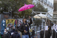 A stall-holder sets up his display in the Rastro flea market in Madrid, Spain, Sunday, Nov. 22, 2020. Madrid's ancient and emblematic Rastro flea market reopened Sunday after a contentious eight-month closure because of the COVID-19 pandemic that has walloped the Spanish capital. (AP Photo/Paul White)