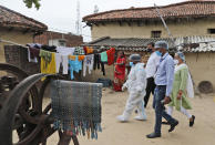 Health workers arrive to test villagers for COVID-19 and to persuade them get vaccinated at Sikanderpur village, Uttar Pradesh state, India, on June 9, 2021. India's vaccination efforts are being undermined by widespread hesitancy and fear of the jabs, fueled by misinformation and mistrust. That's especially true in rural India, where two-thirds of the country’s nearly 1.4 billion people live. (AP Photo/Rajesh Kumar Singh)