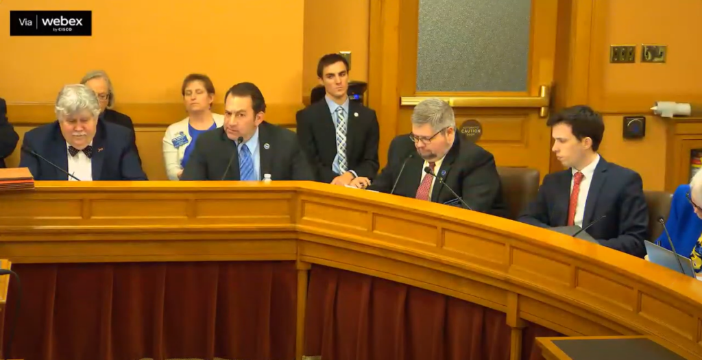 Republican Rep. Troy Waymaster, center, discusses with Senate budget negotiators provisions authorizing the state to issue $200 million in STAR bonds to support development of a Mattel themed park in Bonner Springs and a large-scale manufacturing plant in Wichita. (Kansas Reflector screen capture from Kansas Legislature's YouTube channel)