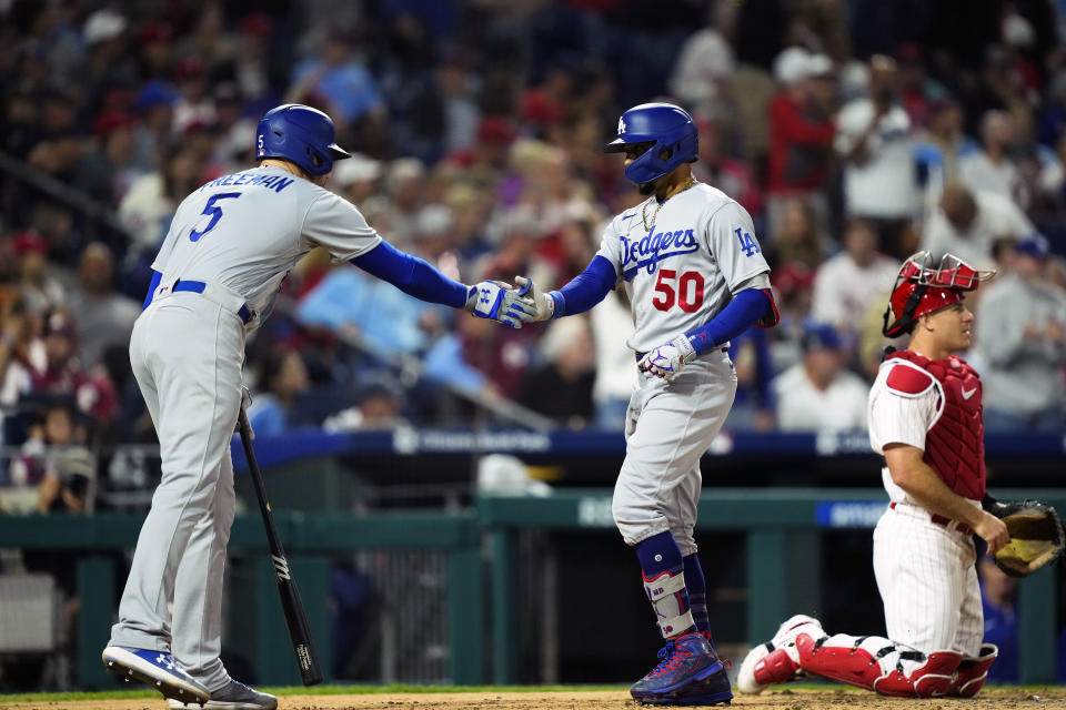 Los Angeles Dodgers' Mookie Betts (50) celebrates after his two-run home run off Philadelphia Phillies' Matt Strahm with Freddie Freeman, left, during the seventh inning of a baseball game, Friday, June 9, 2023, in Philadelphia. (AP Photo/Matt Rourke)